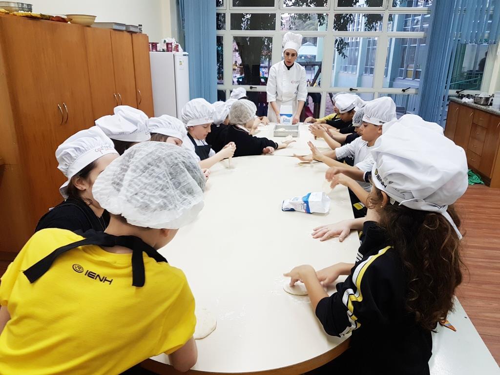 Estudantes bilíngues preparam pizzas saudáveis no projeto Cozinha que Inspira